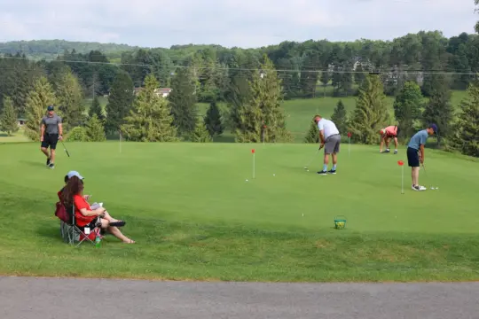 Golfers practice on the putting green.