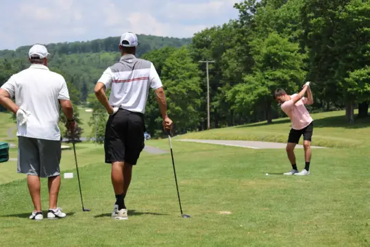 Golfer swings on hole 10 during golf tournament.