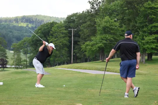 Golfer swings on hole 10 during golf tournament.
