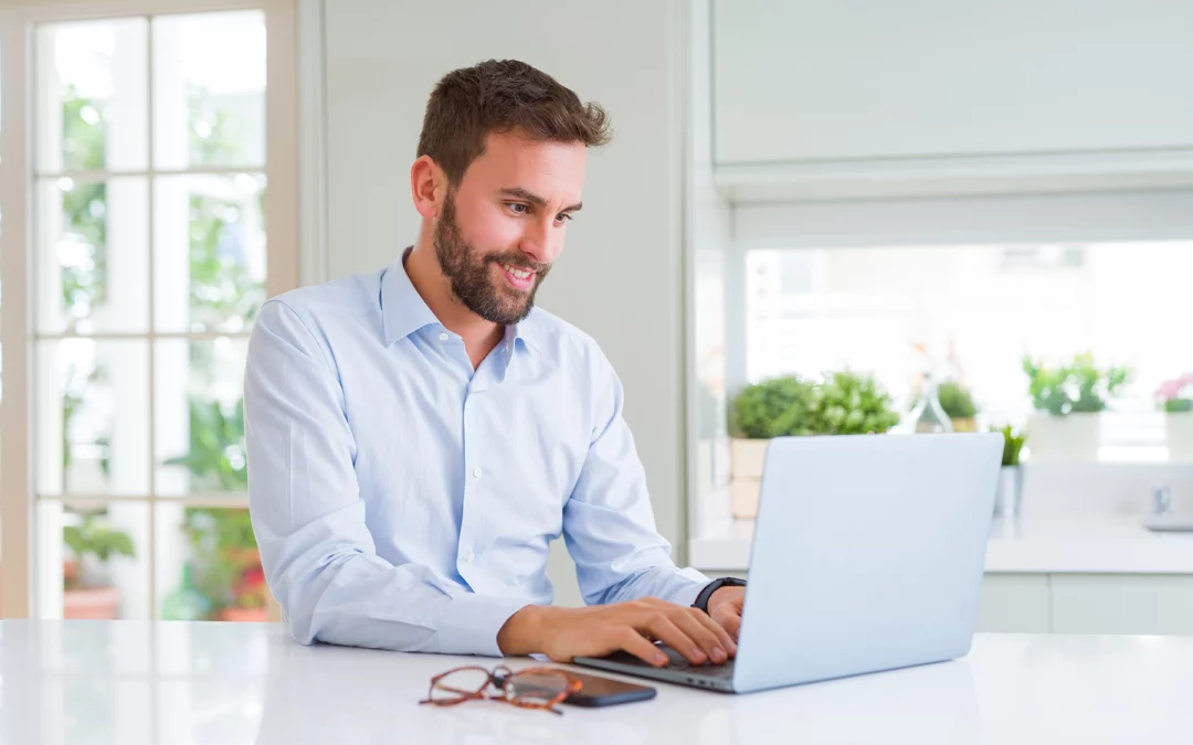 A business man working on a laptop at a counter.