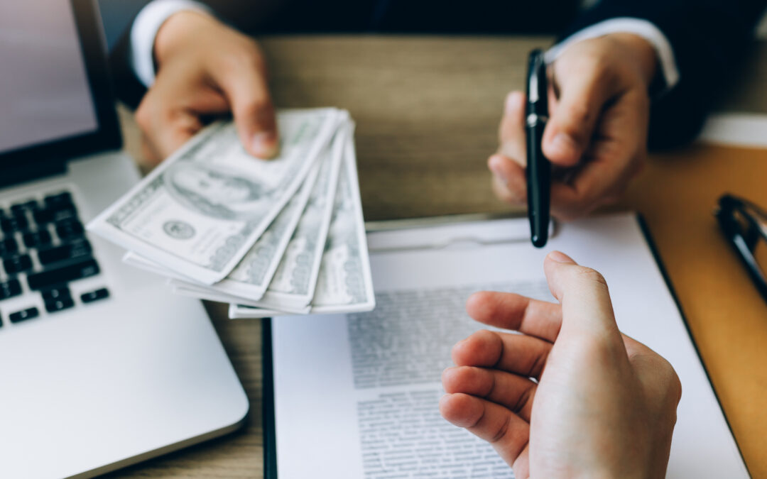 A banker gives a loan to a business owner.