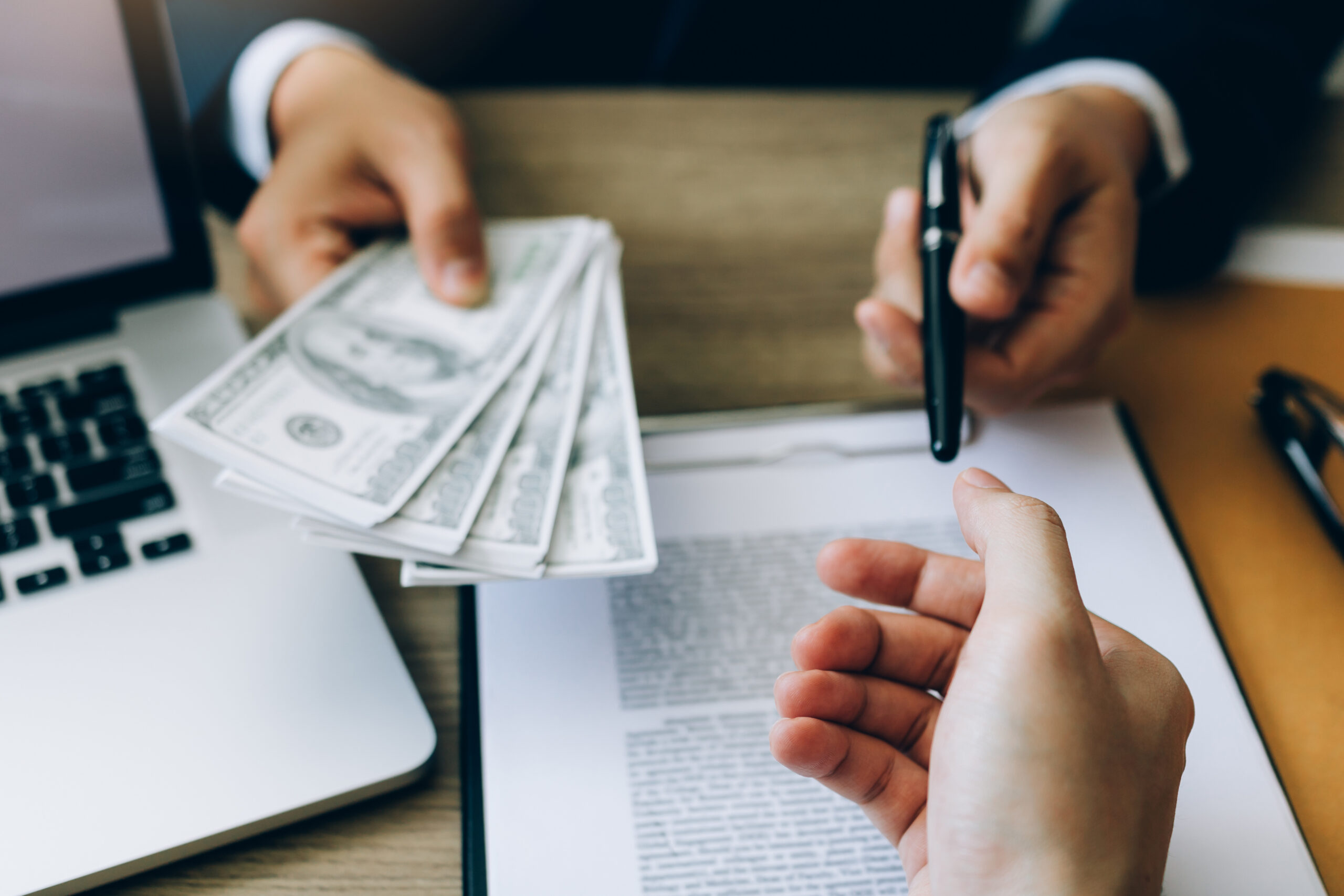 A banker gives a loan to a business owner.