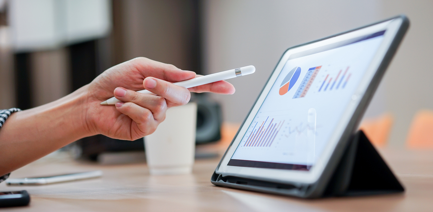 A sales person points at their tablet with a stylus in their hand.