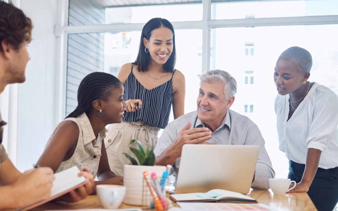 A corporate team works collaboratively around a large table.