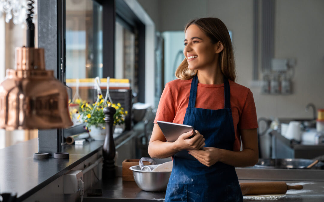 A happy small business owner smiles in her workplace.