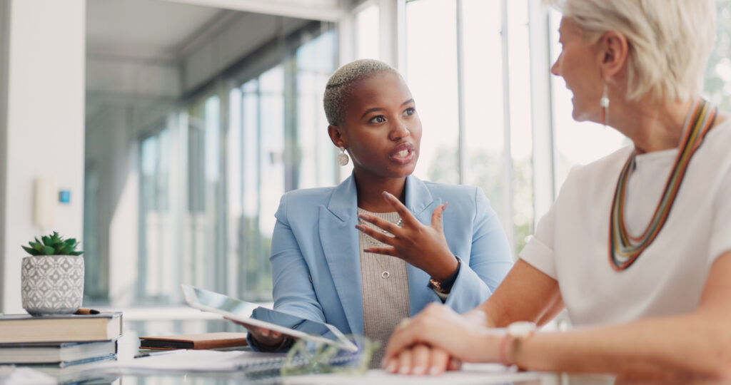 Two business women in discussion about finances in the office.